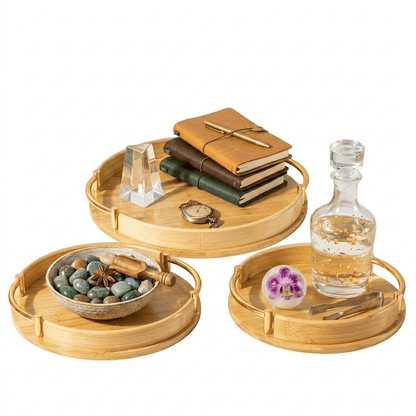 Plateaux ronds en bambou avec poignées dorées, idéaux pour décoration ou service, présentant livres, pierres et accessoires élégants.