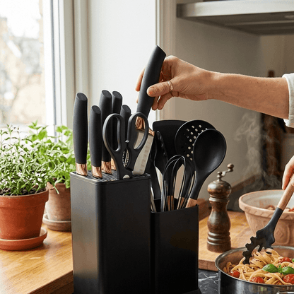 Ensemble de couteaux de cuisine noirs avec manches cuivrés, rangés dans un bloc moderne, idéal pour la préparation culinaire