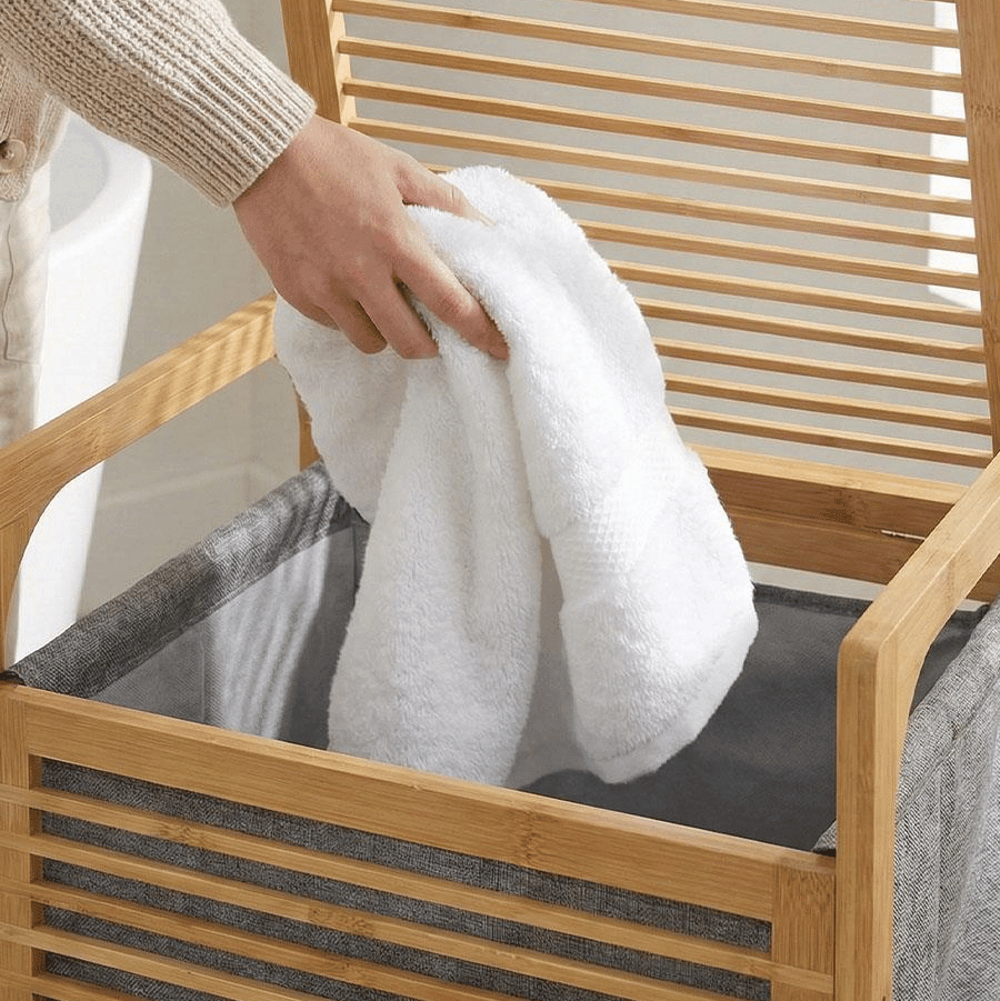 Panier à linge en bambou avec serviette blanche, rangement salle de bain pratique et élégant