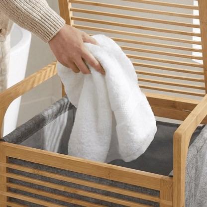 Panier à linge en bambou avec serviette blanche, rangement salle de bain pratique et élégant